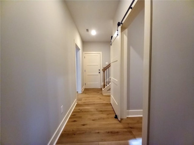 136 Rainey Rd, Temple, GA 30179 - hall featuring light wood finished floors, a barn door, and stairway