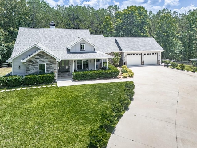 430 Cajun Dr, Ellijay, GA 30540 - view of front of home featuring stone siding, concrete driveway, covered porch, a garage, and a chimney