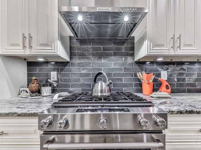 430 Cajun Dr, Ellijay, GA 30540 - kitchen view of stainless steel gas stove, exhaust hood, white cabinets, tasteful backsplash, and light stone countertops