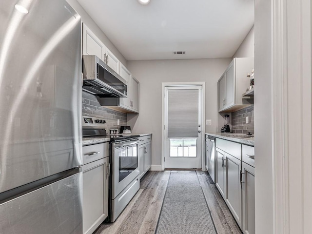 430 Cajun Dr, Ellijay, GA 30540 - kitchen with stainless steel appliances, light wood-style floors, backsplash, and light stone counters