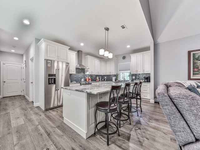 430 Cajun Dr, Ellijay, GA 30540 - kitchen with stainless steel appliances, wall chimney range hood, a kitchen island, white cabinetry, and decorative backsplash