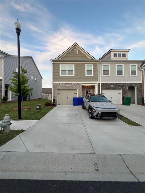 multi unit property with a garage and a front yard