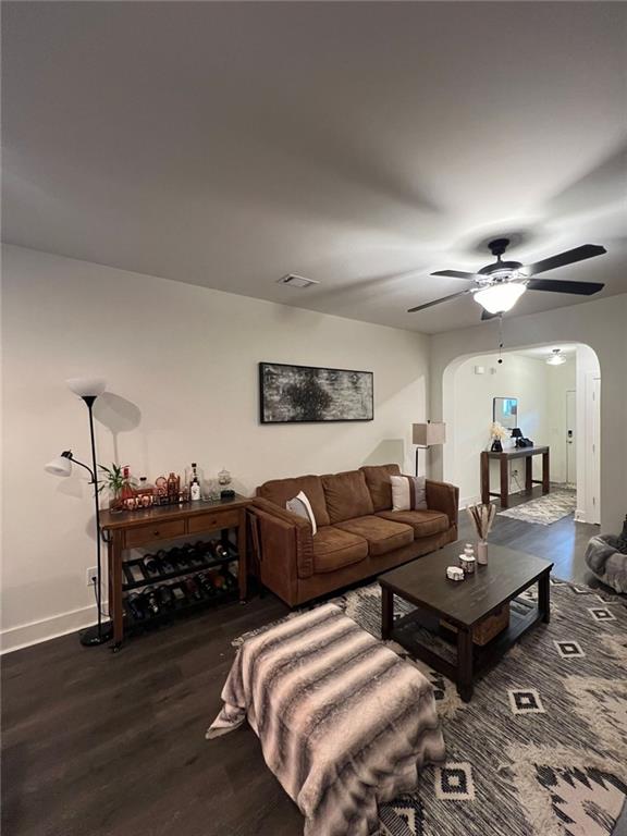 living room with dark hardwood / wood-style floors and ceiling fan