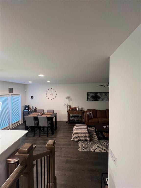 living room featuring ceiling fan and dark hardwood / wood-style floors