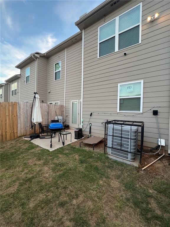 back of house with a lawn, central air condition unit, and a patio