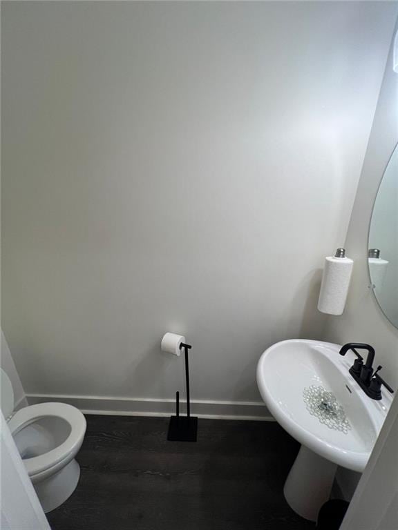 bathroom with sink, wood-type flooring, and toilet