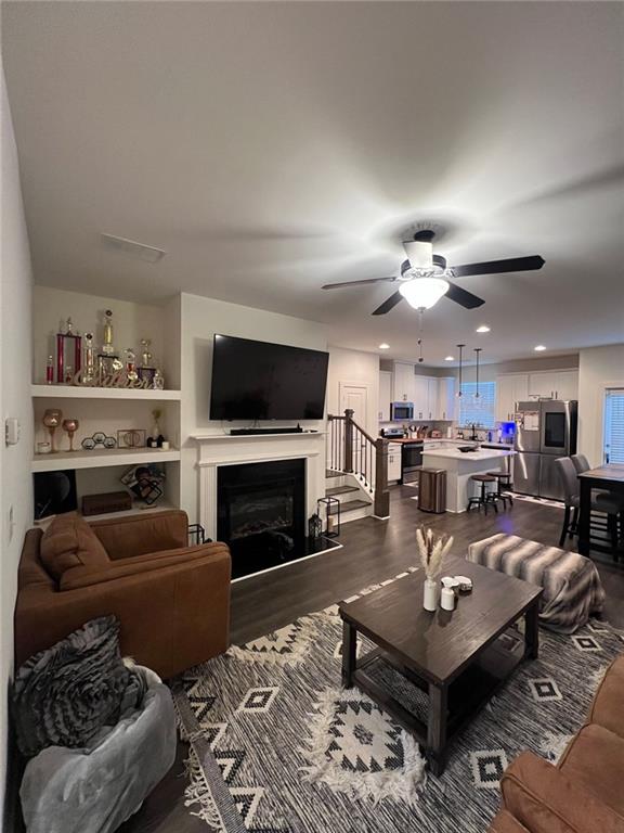 living room featuring ceiling fan and wood-type flooring