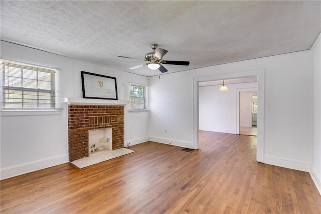 1834 Broad Ave, Atlanta, GA 30344 - unfurnished living room featuring ceiling fan, light wood-style flooring, baseboards, a fireplace, and a textured ceiling
