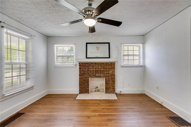 1834 Broad Ave, Atlanta, GA 30344 - unfurnished living room featuring plenty of natural light, wood finished floors, a brick fireplace, ceiling fan, and a textured ceiling