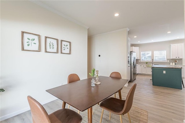 dining room featuring crown molding and light wood-type flooring