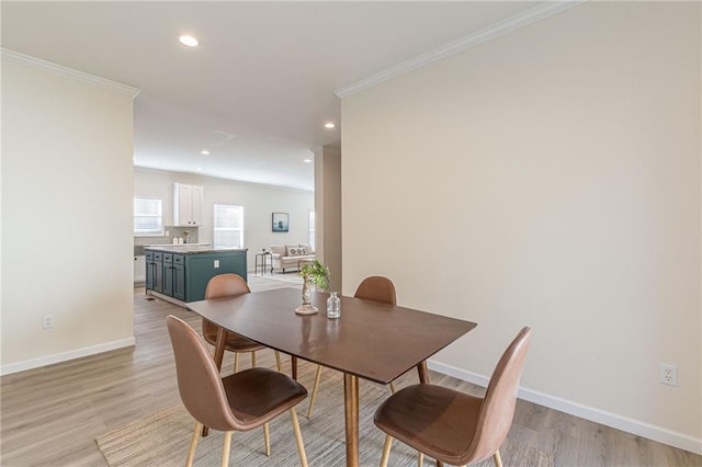 dining room with light wood-type flooring and ornamental molding