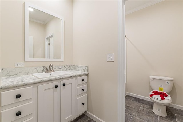 bathroom with crown molding, vanity, and toilet