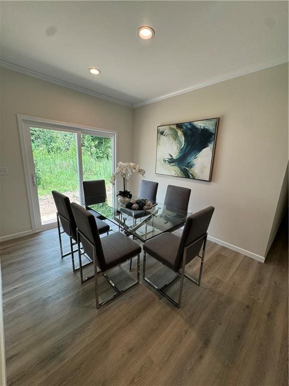 dining area with ornamental molding and dark wood-type flooring