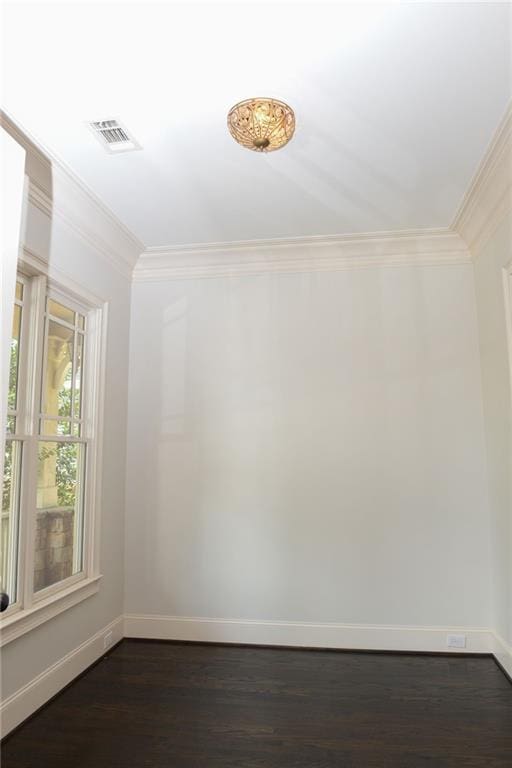 empty room with dark hardwood / wood-style flooring and ornamental molding