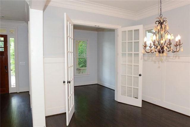 foyer featuring a chandelier, french doors, ornamental molding, and dark wood-type flooring