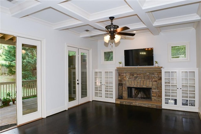 unfurnished living room featuring coffered ceiling, ceiling fan, french doors, a stone fireplace, and dark hardwood / wood-style floors