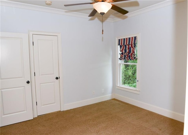 spare room with light carpet, ornamental molding, and ceiling fan