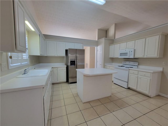 kitchen with a center island, light countertops, white cabinetry, a sink, and white appliances