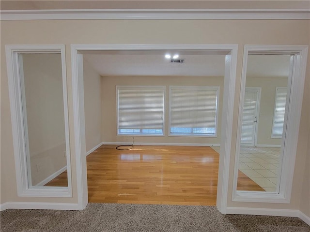 interior space with wood finished floors, visible vents, and baseboards