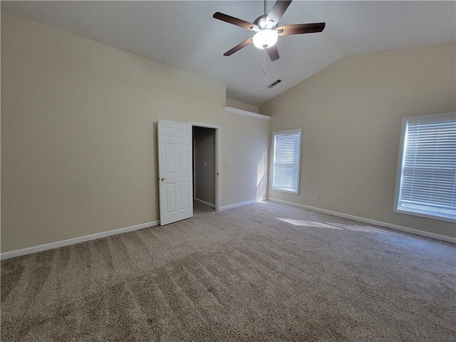 carpeted spare room featuring lofted ceiling, a ceiling fan, visible vents, and baseboards