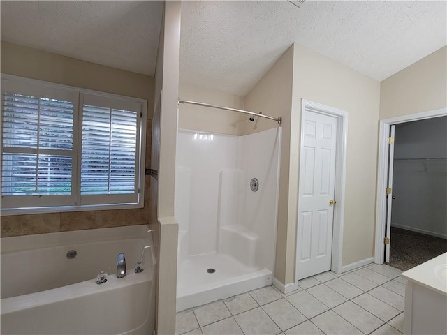 full bath with a textured ceiling, walk in shower, a bath, and tile patterned floors