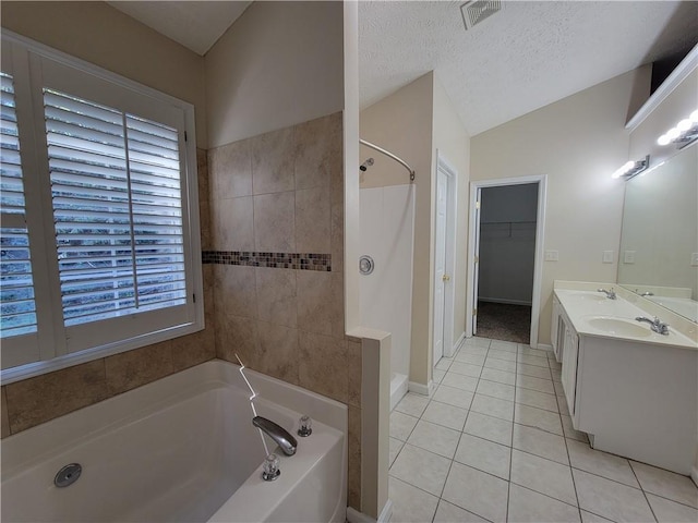 full bathroom with a garden tub, lofted ceiling, visible vents, a textured ceiling, and tile patterned flooring