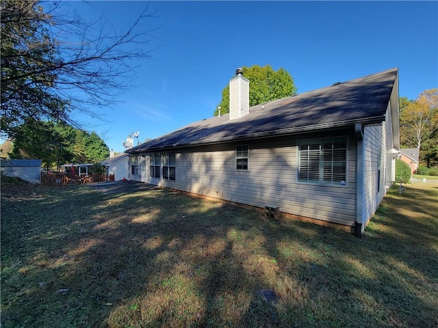 back of house with a yard and a chimney