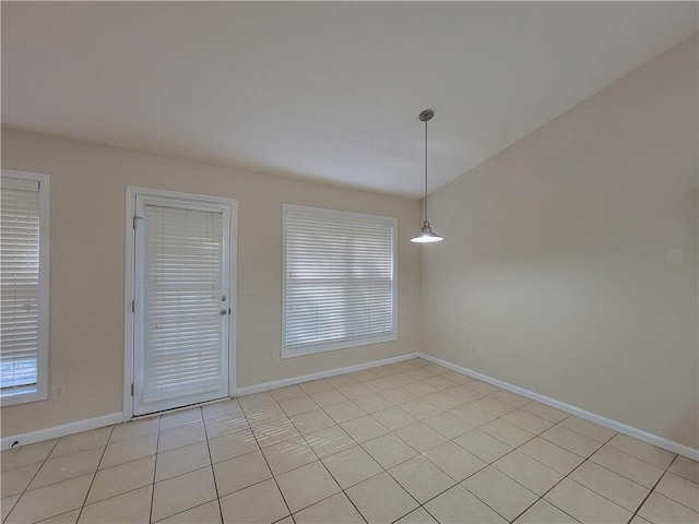 unfurnished room featuring baseboards and light tile patterned floors