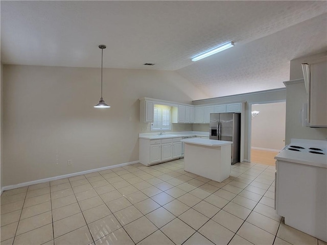 kitchen with lofted ceiling, a kitchen island, light countertops, stainless steel refrigerator with ice dispenser, and a sink