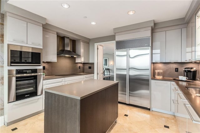 750 Park Ave NE Unit 19E, Atlanta, GA 30326 - kitchen featuring tasteful backsplash, a center island, wall chimney range hood, stainless steel appliances, and modern cabinets