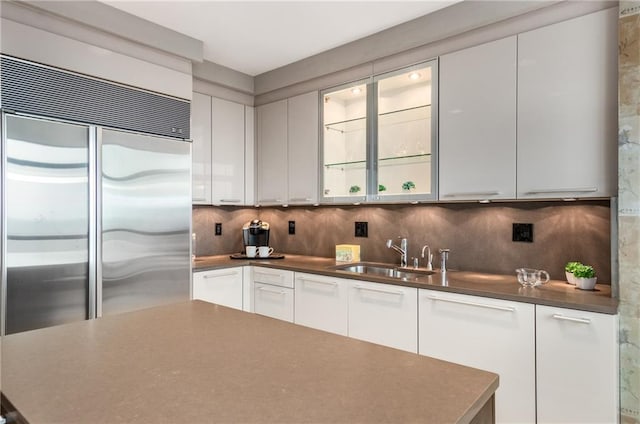 750 Park Ave NE Unit 19E, Atlanta, GA 30326 - kitchen with tasteful backsplash, white cabinetry, stainless steel built in fridge, and a sink