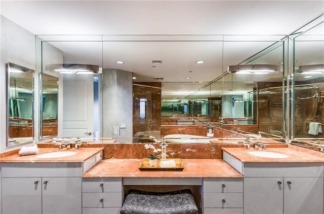 750 Park Ave NE Unit 19E, Atlanta, GA 30326 - bathroom with double vanity, visible vents, a shower stall, and a sink