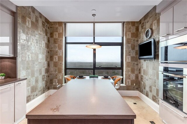 750 Park Ave NE Unit 19E, Atlanta, GA 30326 - kitchen with pendant lighting, tile walls, and white cabinets