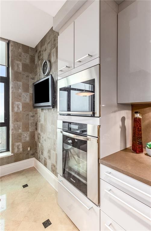 750 Park Ave NE Unit 19E, Atlanta, GA 30326 - kitchen with white cabinets, baseboards, and appliances with stainless steel finishes