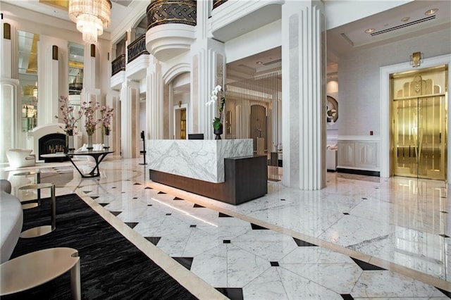 750 Park Ave NE Unit 19E, Atlanta, GA 30326 - reception featuring decorative columns, a chandelier, and a fireplace