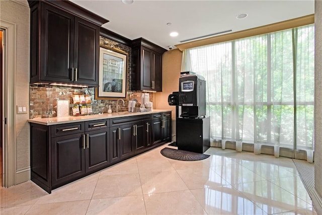750 Park Ave NE Unit 19E, Atlanta, GA 30326 - kitchen featuring decorative backsplash, light countertops, light tile patterned floors, and a sink