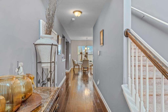 hall with stairs, hardwood / wood-style floors, and baseboards