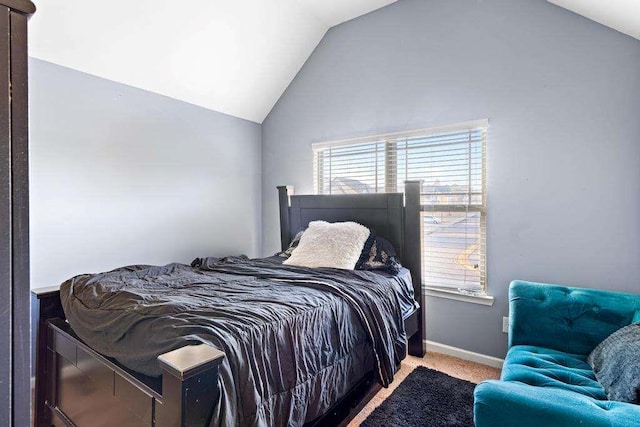 carpeted bedroom with vaulted ceiling and baseboards