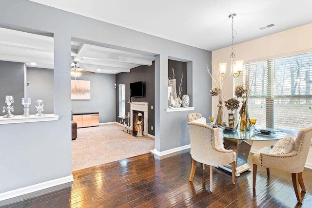 dining space with coffered ceiling, a fireplace with flush hearth, visible vents, baseboards, and hardwood / wood-style floors