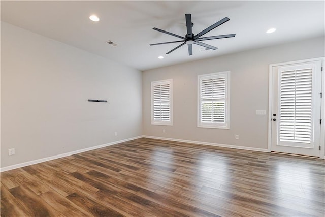 empty room with baseboards, ceiling fan, visible vents, and wood finished floors