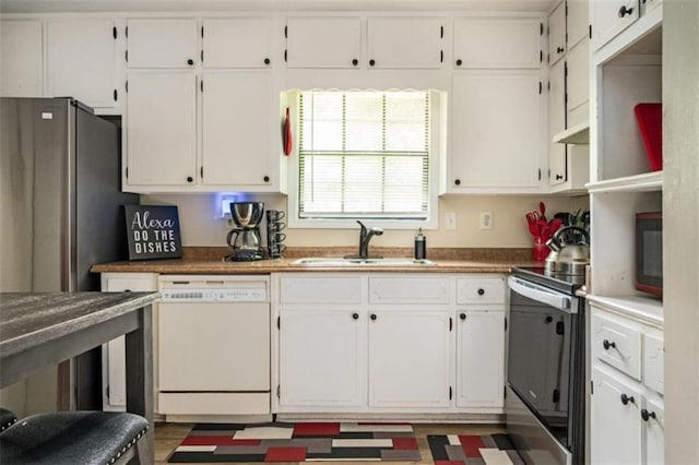 kitchen featuring white cabinets, stainless steel electric range oven, white dishwasher, and a sink