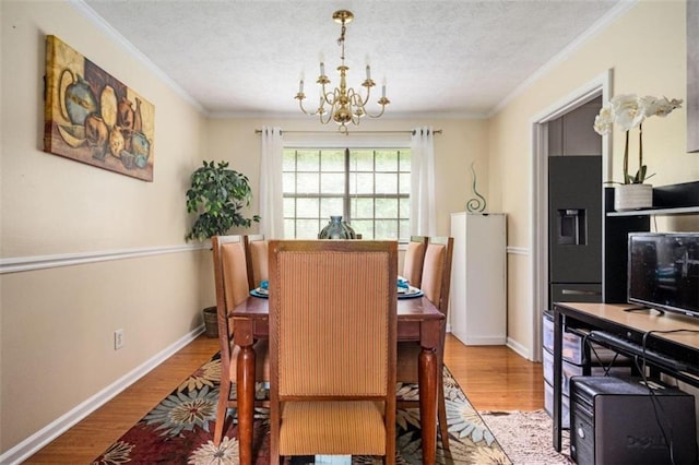 dining space with crown molding, a chandelier, and wood finished floors