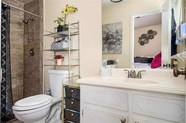 full bath with tiled shower, vanity, toilet, and ensuite bathroom