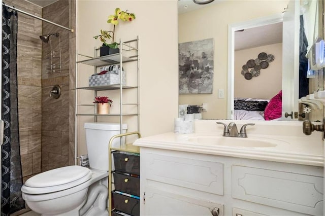 bathroom featuring vanity, toilet, and a tile shower
