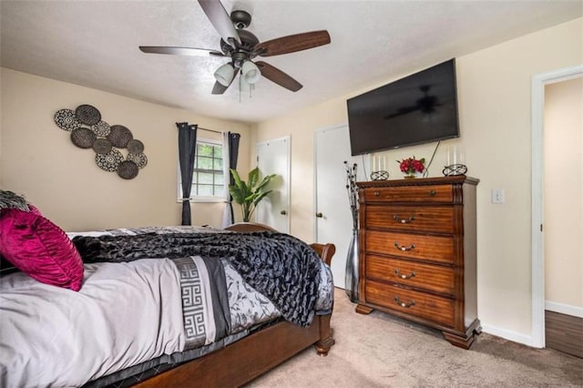 carpeted bedroom with ceiling fan and baseboards