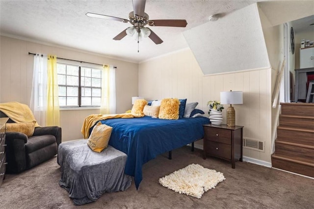 bedroom with carpet floors, crown molding, visible vents, a ceiling fan, and a textured ceiling