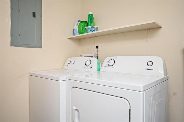 clothes washing area with electric panel, laundry area, and washer and dryer