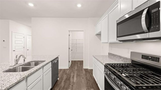 kitchen featuring white cabinets, sink, light stone countertops, appliances with stainless steel finishes, and dark hardwood / wood-style flooring