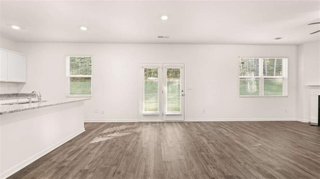 unfurnished living room featuring ceiling fan, dark hardwood / wood-style flooring, and sink