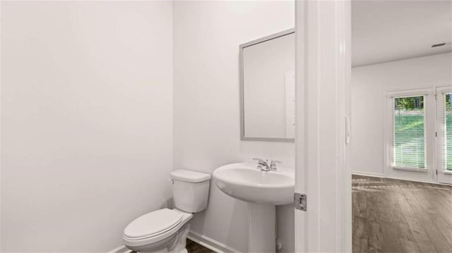 bathroom with hardwood / wood-style flooring, toilet, and sink